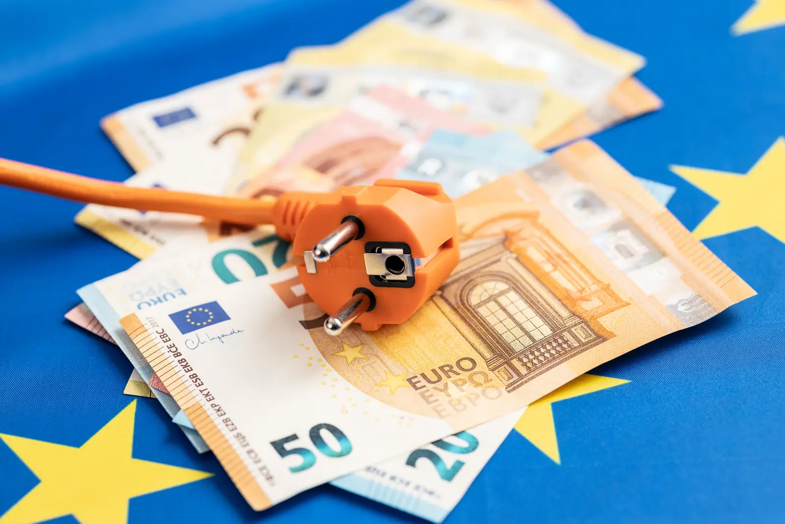 Electrical plug resting on Euro banknotes, representing energy cost