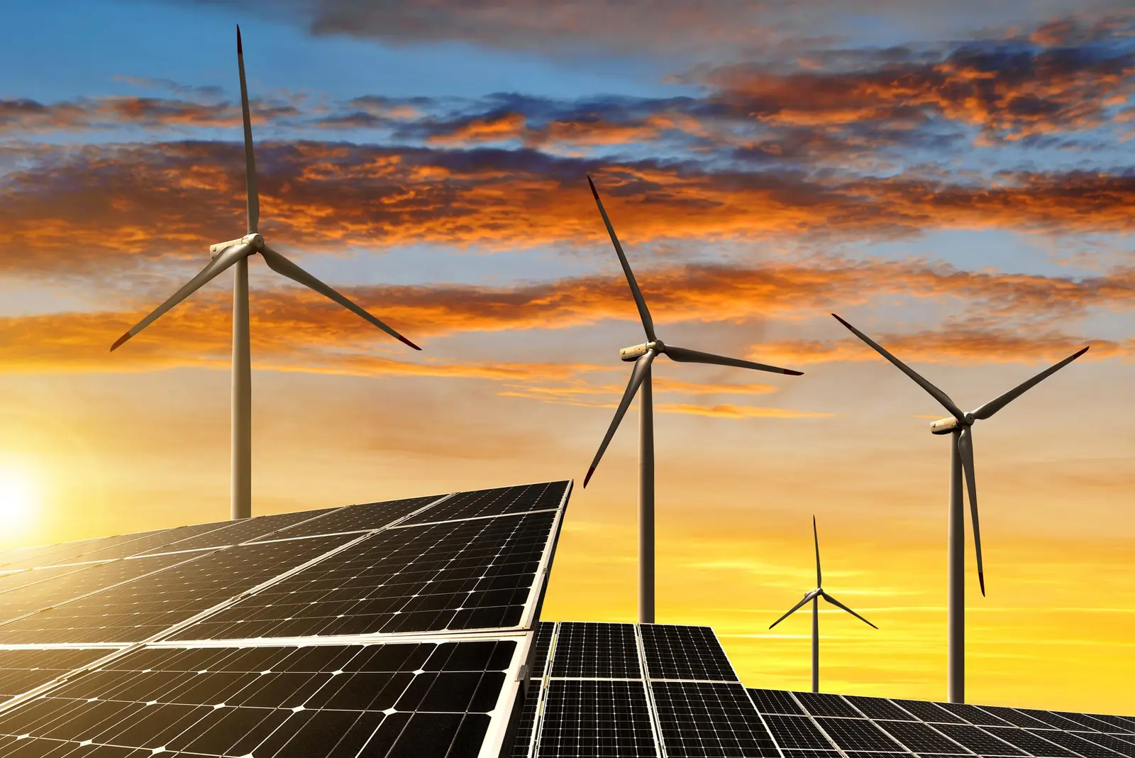Solar panels and wind turbines at sunset